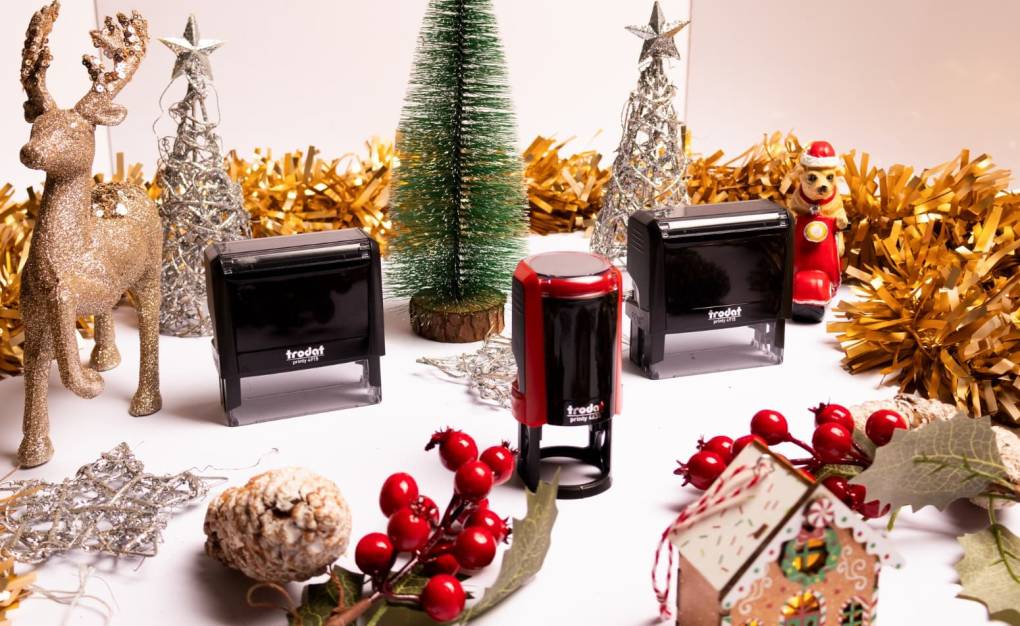 Trodat Stempelmodelle als Weihnachtsgeschenk, dekoriert mit Tannenbaum, Hirsch, Christbaumkugeln und Lebkuchenhaus