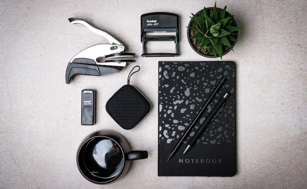 Flat lay mit Büroaccessoires, Stempel, Notizbuch und Pflanzenelementen mit Label Easy-News