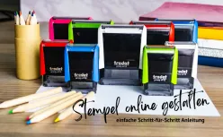 Bunte Trodat Stempel auf Schreibtisch mit Buntstiften und Text 'Stempel online gestalten - einfache Schritt-für-Schritt- Anleitung'