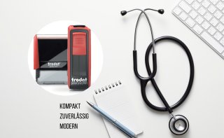 Stempel in Rot und Schwarz neben Stethoskop, Tastatur und Notizblock auf hellem Hintergrund mit den Worten „kompakt, zuverlässig, modern