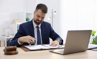 Rechtsanwalt verwendet einen Stempel für Kanzleidokumente im modernen Büro